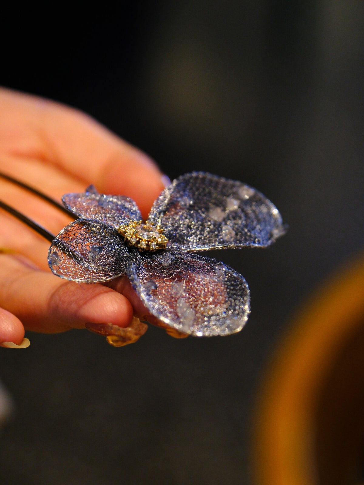 Hand-held close-up of the metal-mesh butterfly hairpin