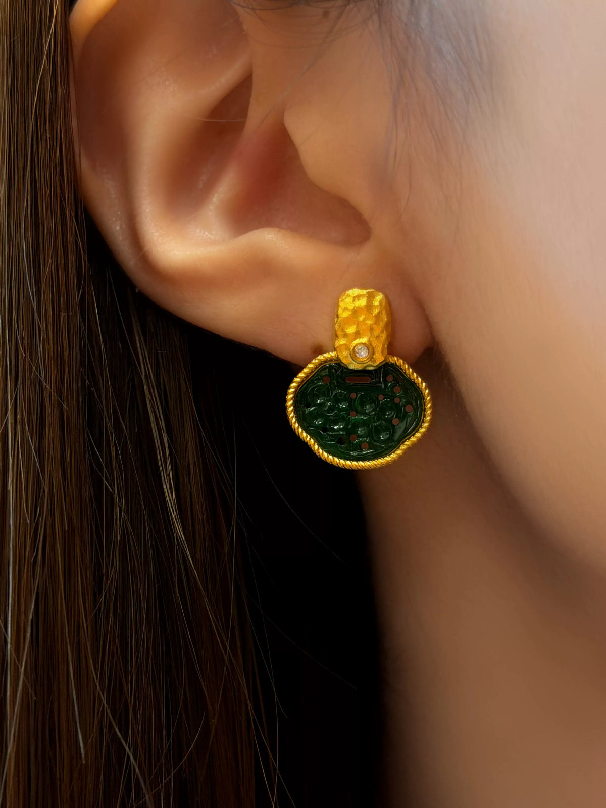 Green and gold-tone garden-window stud earring shown worn on an ear