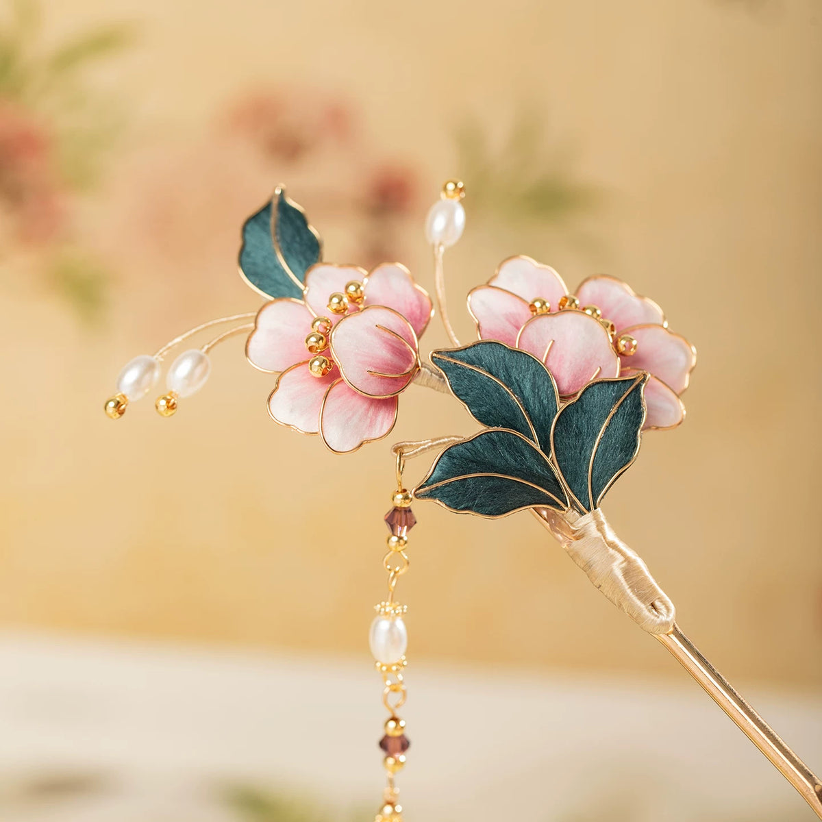 Long pink floral hairpin with dark green leaves, gold-tone outlines, and bead accents