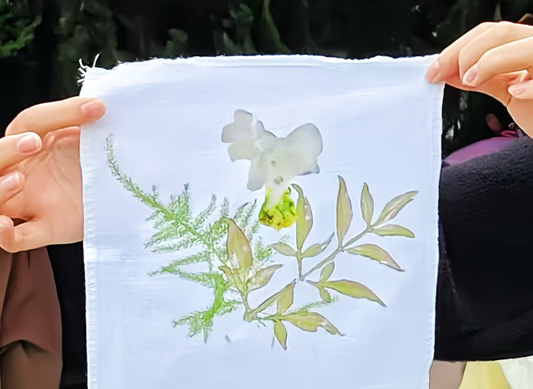 Hands holding a white cloth with flower and leaf impressions