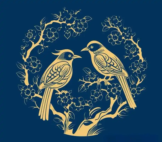 Two golden birds among flowering branches on navy blue