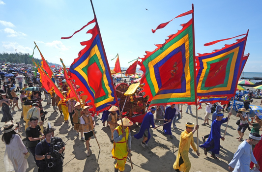 Colorful ceremonial procession during a coastal Gin ethnic community festival