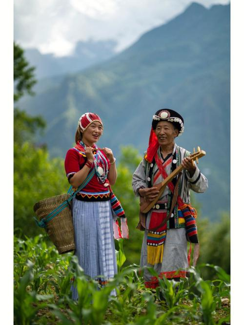 Nu community members in a mountain field, one carrying a basket and one playing a traditional string instrument