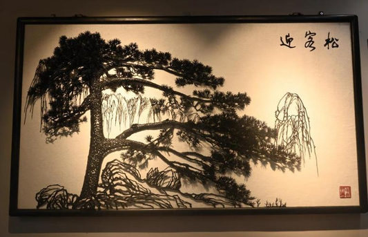 Wuhu iron painting depicting a pine tree and distant mountains