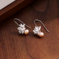Sculpted lotus and pearl drop earrings, shown as a pair