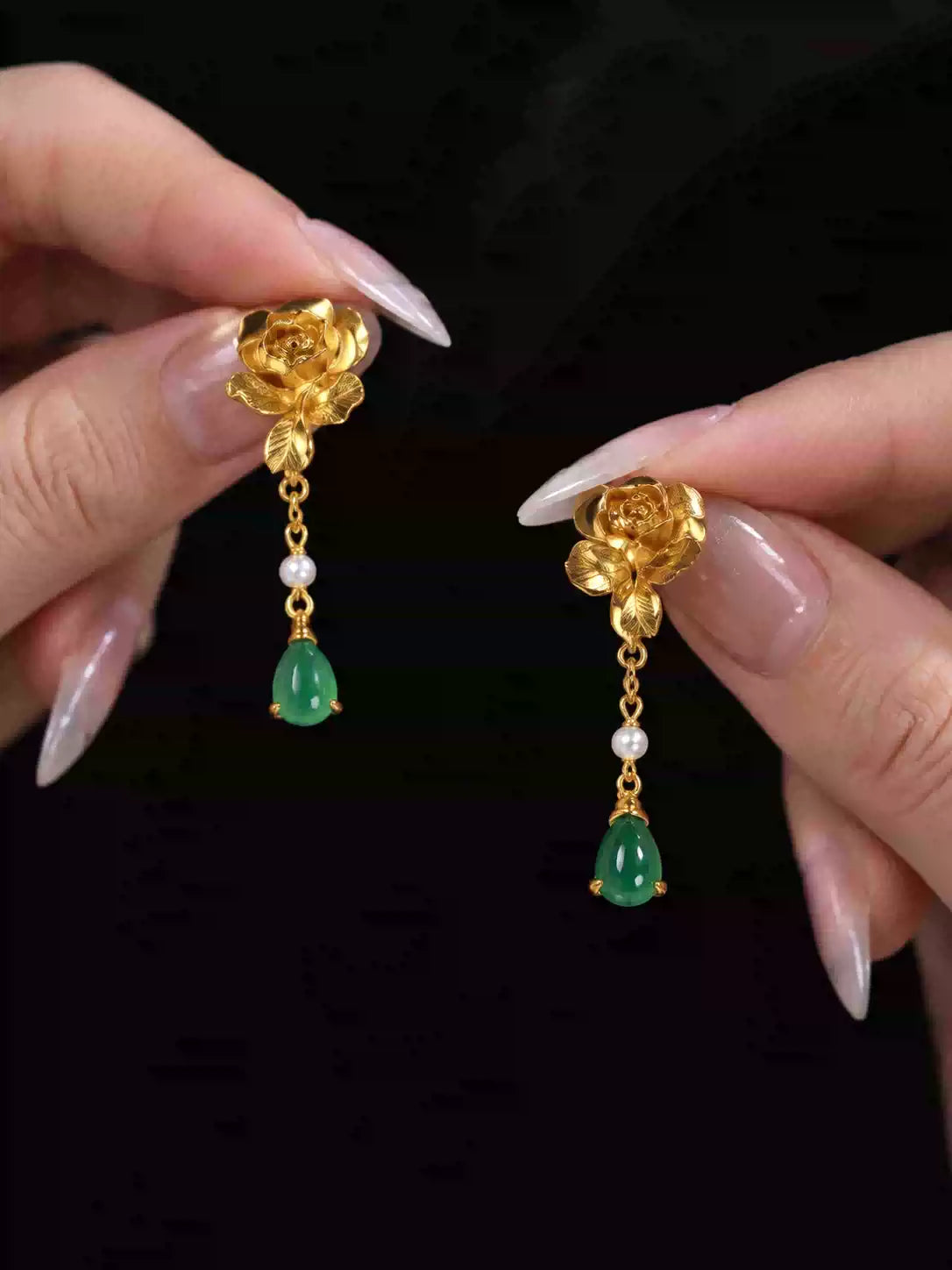 Close-up of the gold-tone lotus-style earrings with green drops