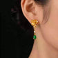 Gold-tone lotus-style drop earrings shown worn