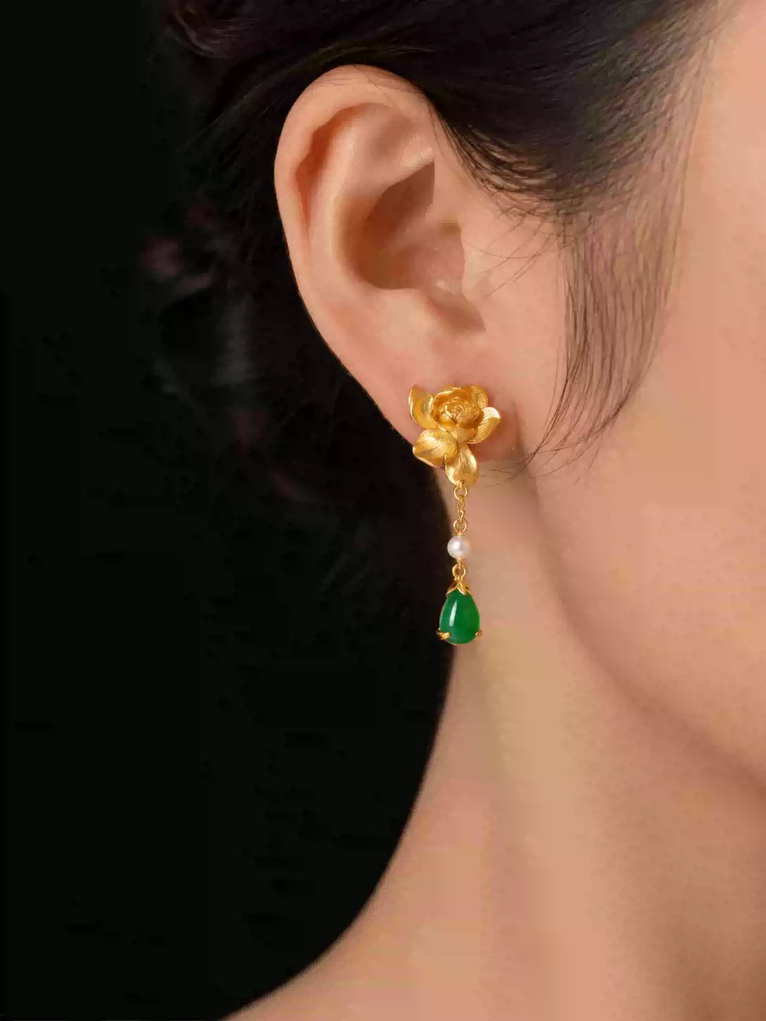 Gold-tone lotus-style drop earrings shown worn