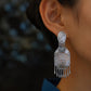Close-up view of a peony drop earring and its dangling tassel details