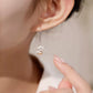 Lotus pearl drop earring worn on the ear
