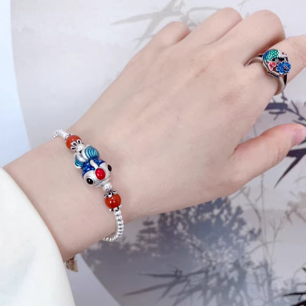Handcrafted silver bracelet featuring feng shui Dudu Fish and natural red agate