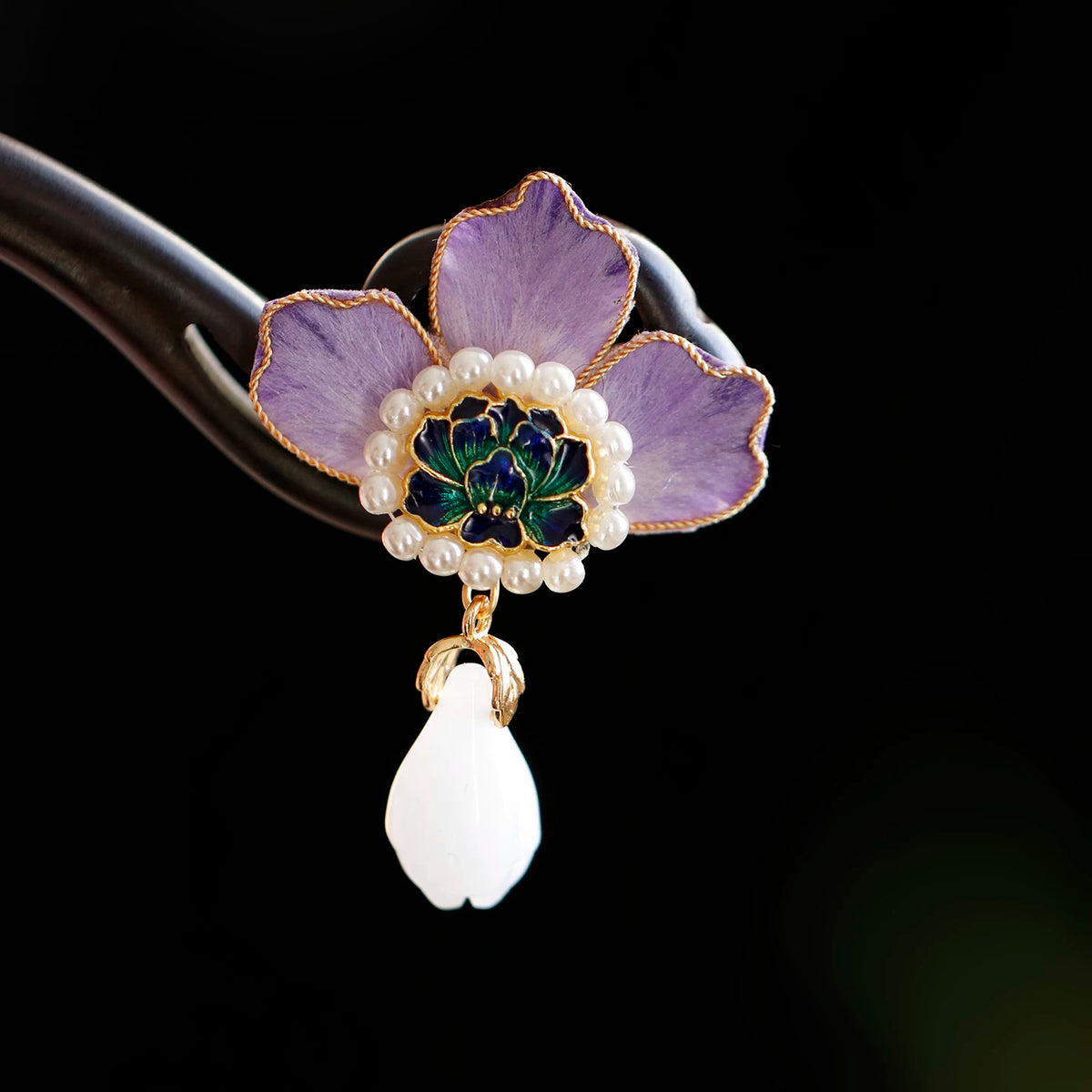 Close-up of purple peony petals, gold edging and drop ornament
