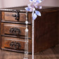 Full view of a purple floral hairpin and long tassel