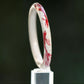 Three-quarter view of the koi motif bangle showing its circular shape and red fish decoration