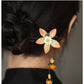 Chrysanthemum and persimmon hair stick worn in a bun