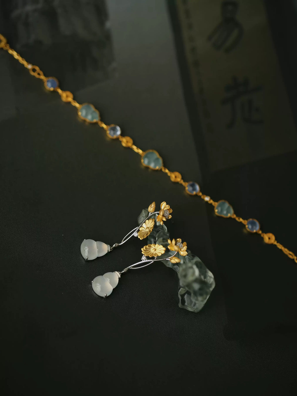 Pair of floral gourd drop earrings shown in a hand for scale.