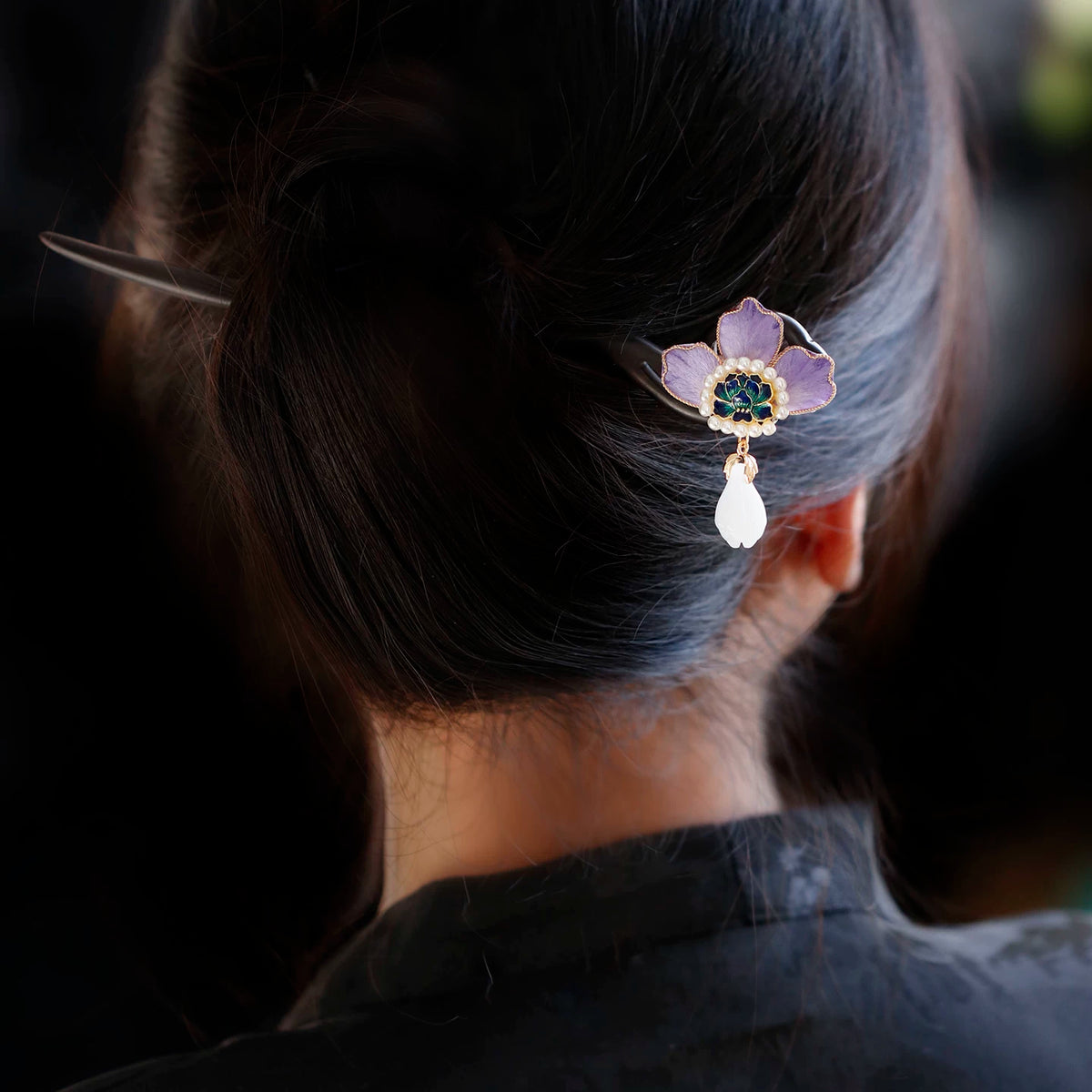 Purple peony tassel hairpin worn in a low bun