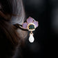 Close view of the purple peony flower and pearl-like accents
