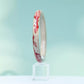 Side view of the koi motif bangle against a pale blue background