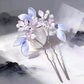 Pair of purple and blue floral hairpins with bead accents and long metal stems
