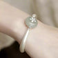 Silver-tone cuff bracelet with lotus pod charm styled on a wrist