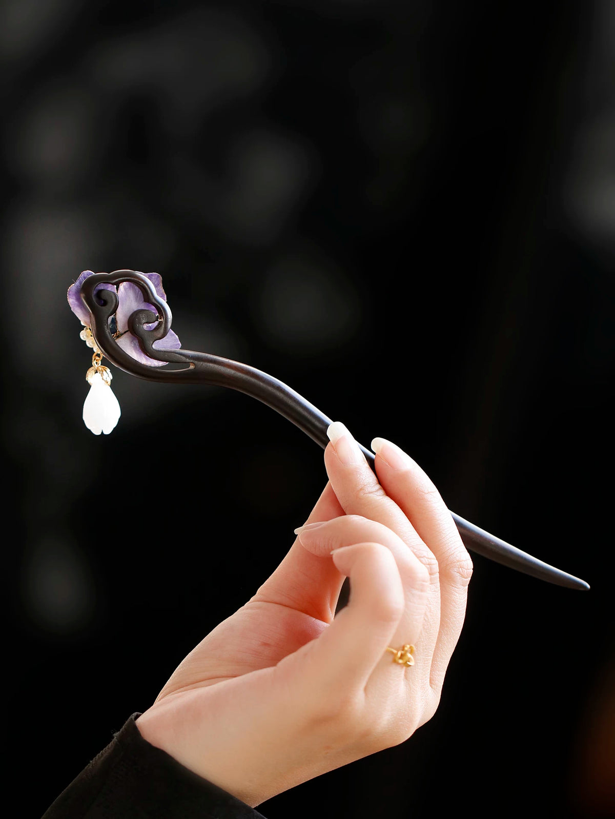 Curved dark wood hairpin with purple flower and drop ornament