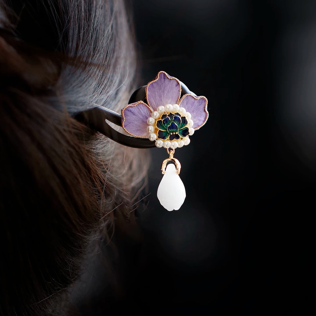 Purple peony wooden hairpin worn in a low bun with a white drop tassel
