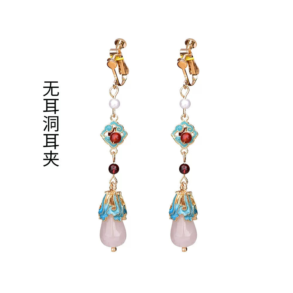 Red and turquoise long drop earrings with clip-on fittings, pair on a clean white background