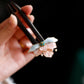 Pink and blue flower hairpin held in hand