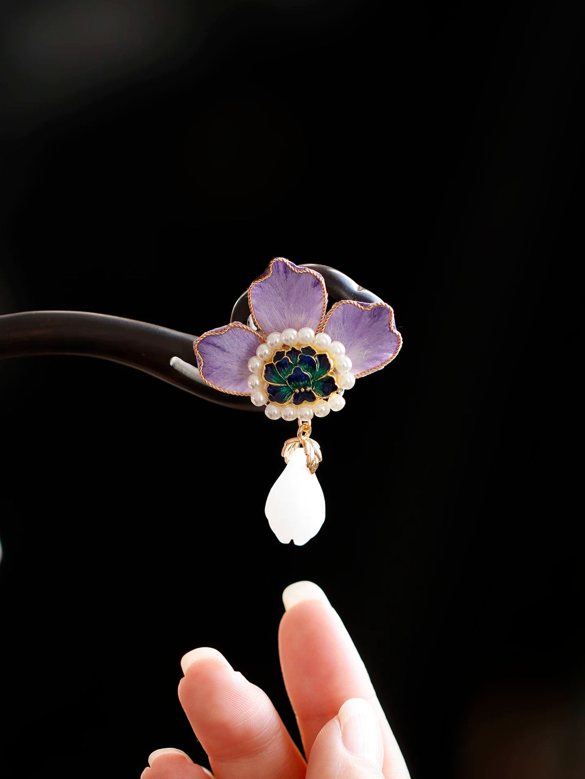Detailed view of the purple peony hairpin held in hand