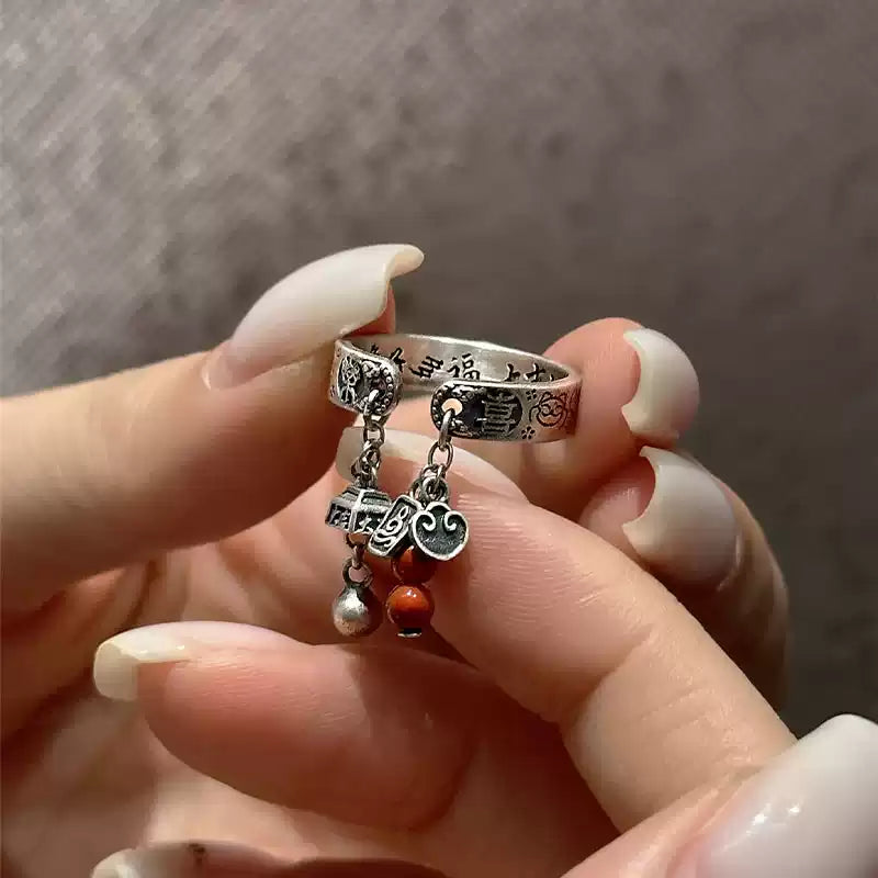 Adjustable silver-tone ring with Chinese character inscription and dangling red bead charms, close-up