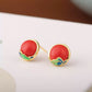 Red cabochon-style stud earrings with gold-tone and blue-green accents.