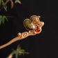 Light green fabric gourd hairpin with stitched floral motif and red accent bead