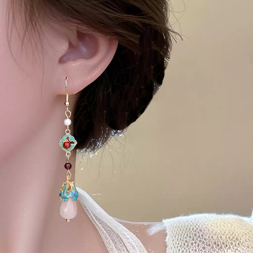 Long red and turquoise earring worn, angled portrait