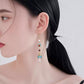 Red and turquoise earrings worn, front close-up
