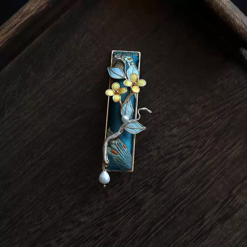Front view of a deep blue brocade hair clip with flower and branch details