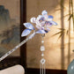 Purple floral tassel hair accessory displayed against a neutral background