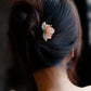 Pink and blue flower hairpin worn in a low bun