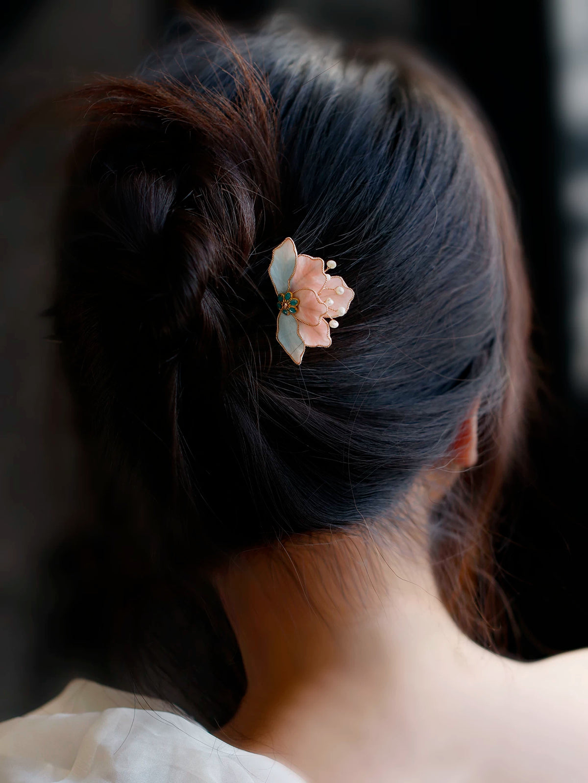 Pink and blue flower hairpin worn in a low bun