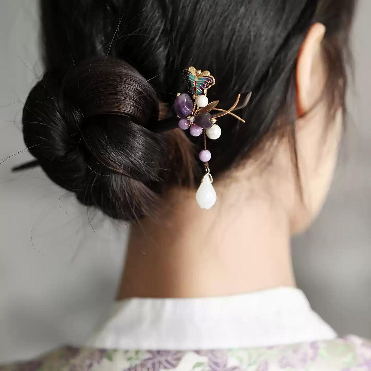 Purple stone butterfly hairpin styled in a low bun