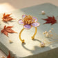 Purple flower ring with a gold-tone alloy band in a styled product scene