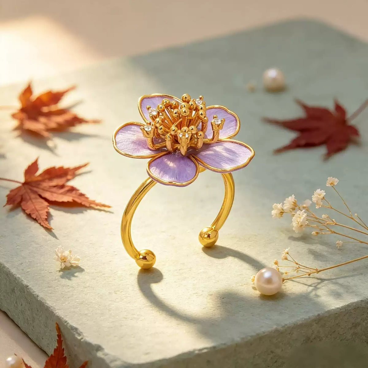 Purple flower ring with a gold-tone alloy band in a styled product scene
