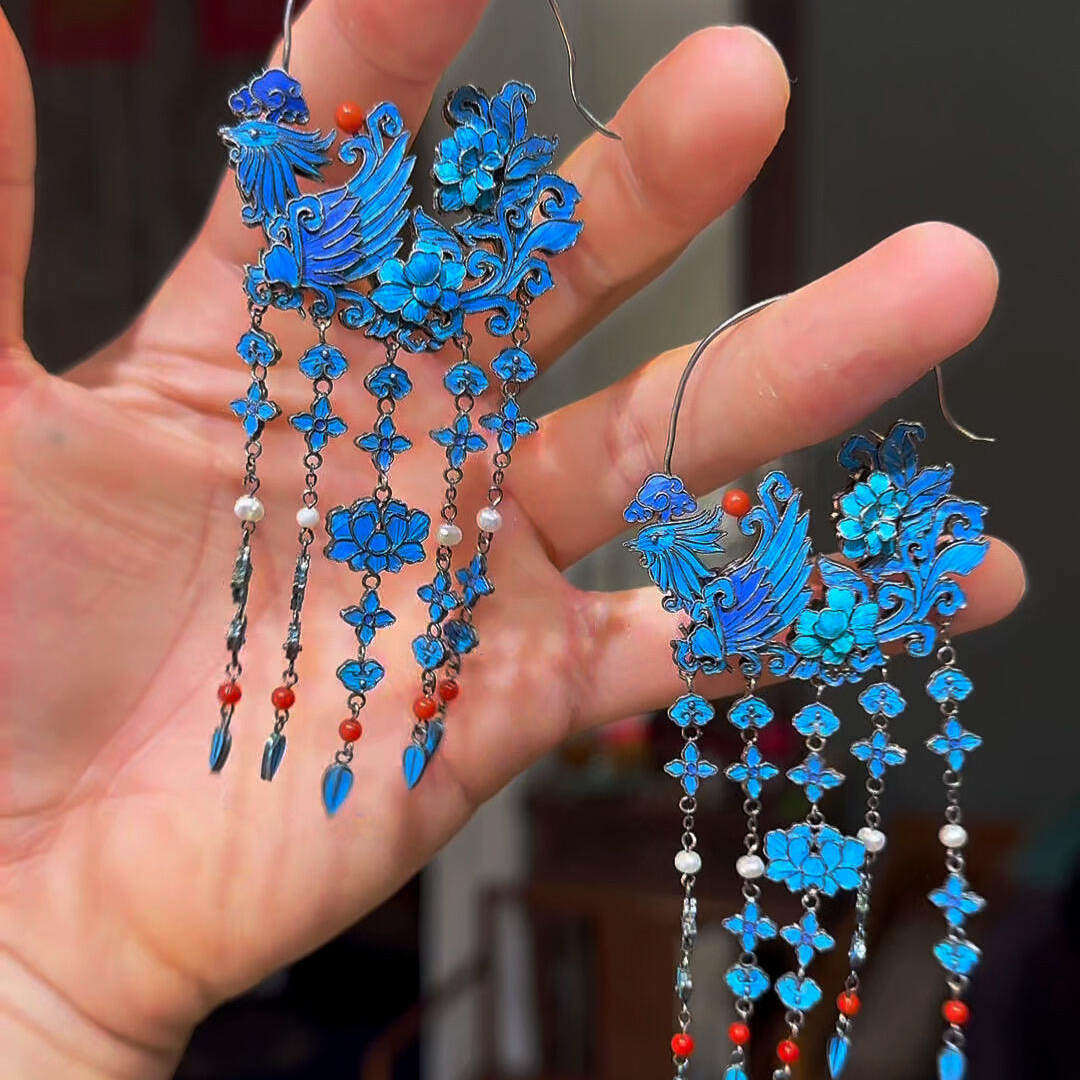 Front view of the phoenix motif pair of blue-and-gold tassel drop earrings