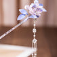 Purple floral hairpin shown on a light background