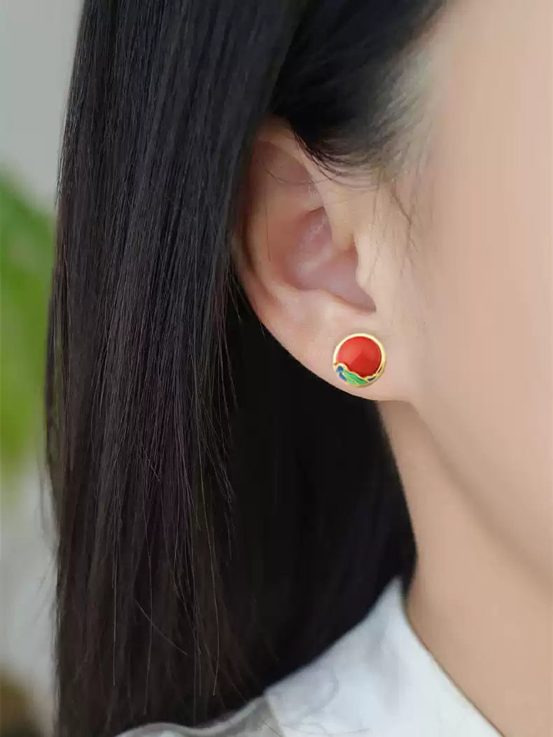 Close-up view of the red stud earrings being worn.