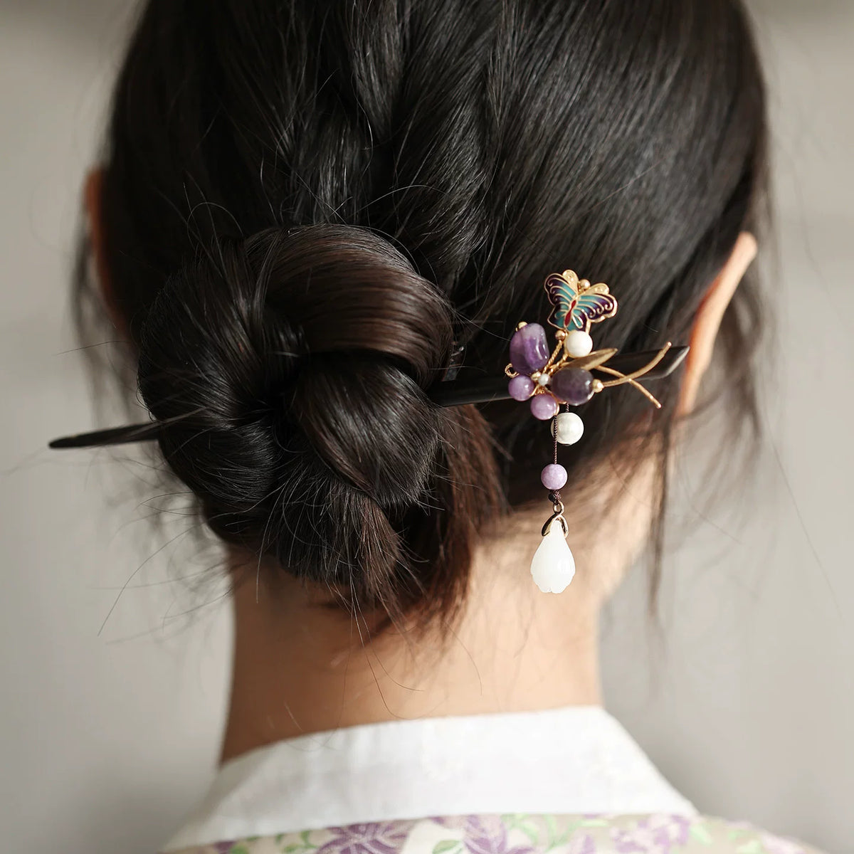 Ebony wood hair stick with butterfly ornament worn in a bun