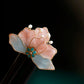 Pink and blue velvet flower detail on a wooden hairpin