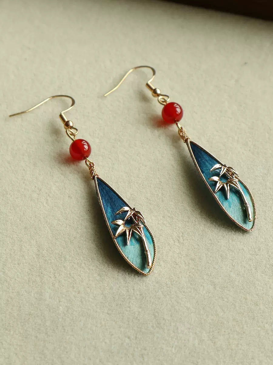Peacock green bamboo leaf teardrop earrings with red bead accents, main product view