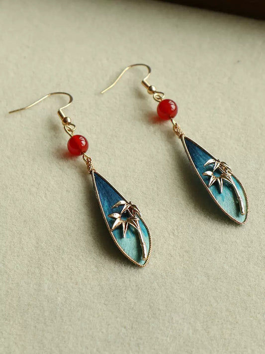 Peacock green bamboo leaf teardrop earrings with red bead accents, main product view