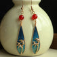 Pair of bamboo leaf teardrop earrings displayed against a dark background